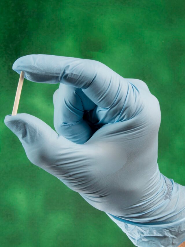 hand in rubber gloves holding a hormonal implant.