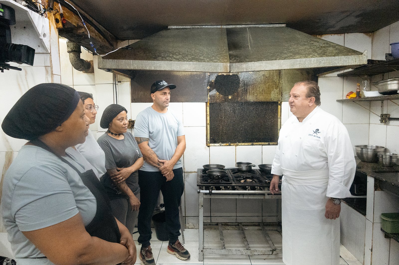 Erick Jacquin conversa com a equipe do Café Cultura Bar em uma cozinha com condições precárias