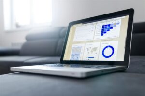 Profissional analisando gráficos de marketing digital em notebook para anunciar em portal de notícias