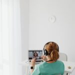 Medica realizando teleconsulta usando computador e fones de ouvido