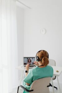 Medica realizando teleconsulta usando computador e fones de ouvido