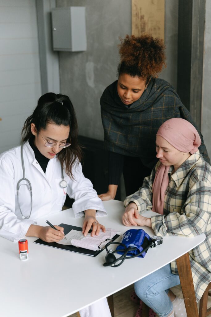 Medica anotando em prontuario durante consulta com paciente